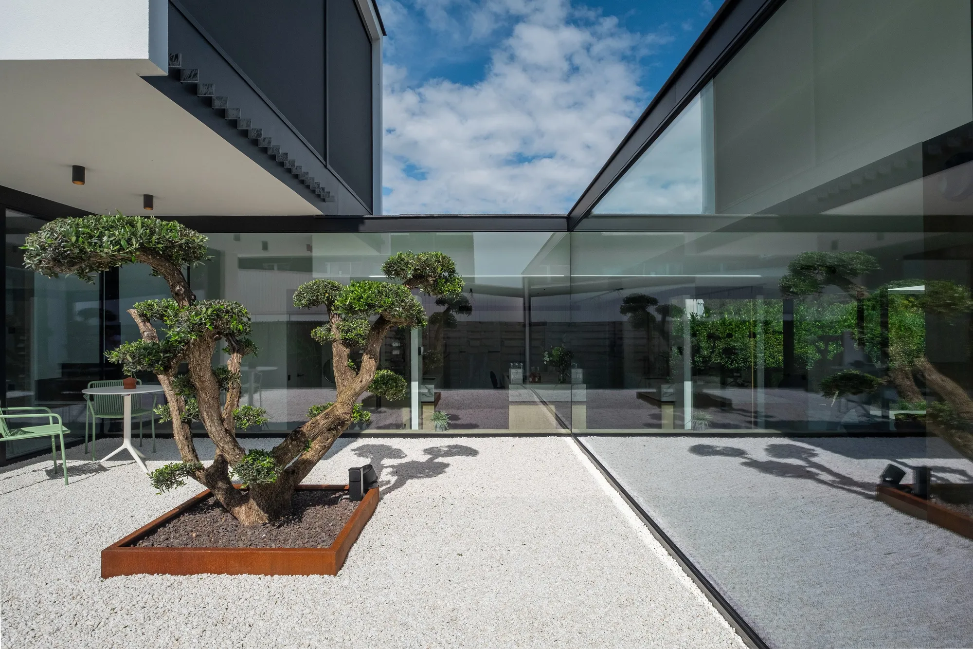 Binnentuin tussen glazen gevels met donkere aluminium profielen
