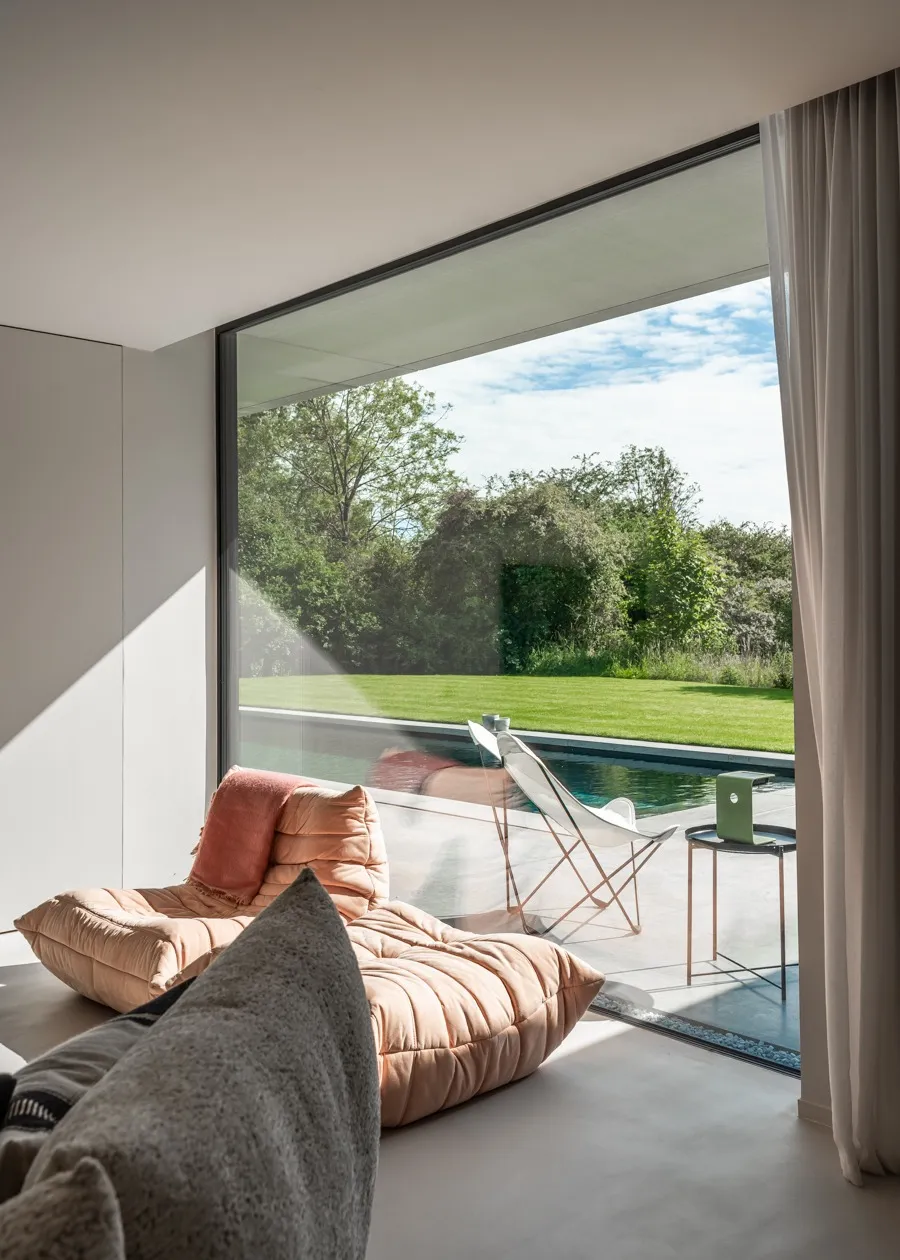 Leefruimte met een groot aluminium raam naar het terras en het zwembad